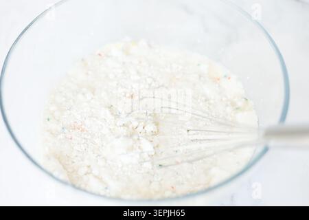 Tortenteig mit Funfetti in einer Glasschale rühren Stockfoto