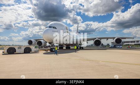 Ein Airbus A380-800 von Emirates wird von einem Schlepper (Trepel Challenger 660) auf dem Vorfeld bewegt. Bodenpersonal in Warnwesten begleitet den Pushback-Vorgang bei wechselhaftem Bewoelkung. ILA Berlin 2026, Berlin, 09.06.2026 Foto: Eibner/Ardan Fuessmann Stockfoto