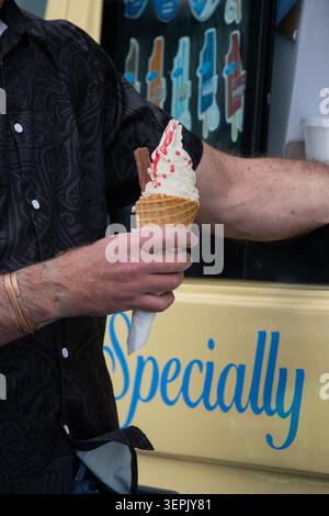 Vanilleeiskegel mit Erdbeersauce und Schokoladenflocke. Stockfoto