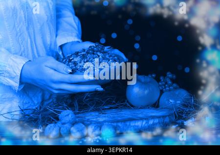 Die Hände interagieren mit traditionellen Kutia und symbolischen Objekten in Szenen, die die Weihnachtszeremonie darstellen. Traditionelle slawische Ritualmahlzeit Kutia Szene mit Emb Stockfoto