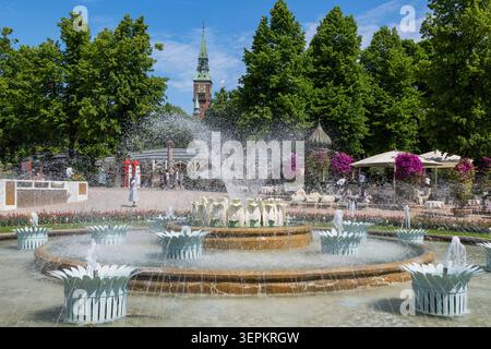 Wasserbrunnen in den Tivoli-Gärten, Kopenhagen, Dänemark mit Rathaus im Hintergrund Stockfoto