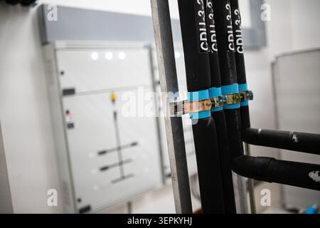Das Bild zeigt eine industrielle Umgebung mit sichtbarer elektrischer Verkabelung, Bedienfeld und Verkabelungsmanagementsystem, die elektrische Installationen hervorhebt Stockfoto