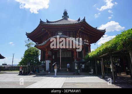 Die verzierte hölzerne Nigatsu-dō-Halle (oder Hokkedo) des Todaiji-Tempels mit seinem eleganten, mehrstufigen, geschwungenen Dach steht im Nara Park, Japan unter einem sonnigen Himmel Stockfoto
