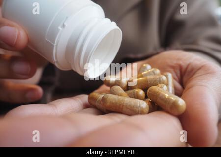Kapseln aus einer Flasche in die Hand einer Person gießen Stockfoto