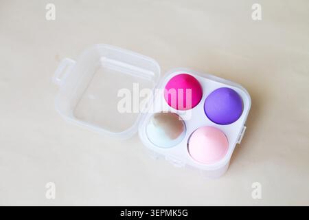 Farbenfrohe Make-up-Schwämme in einer durchsichtigen Box, bereit für die Anwendung in einer Schönheitsroutine Stockfoto