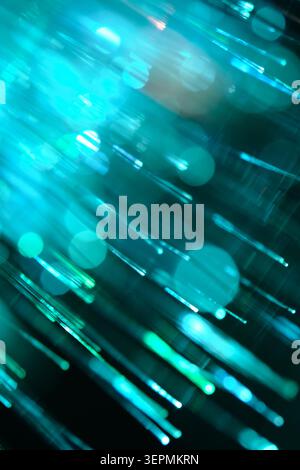 Intensive türkisfarbene und zyanblaue Glasfaserlinien schaffen eine helle abstrakte Textur mit massivem Bokeh Stockfoto