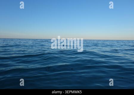 Ein friedlicher Blick auf das weite blaue Meer und den klaren Himmel am Horizont an einem ruhigen, sonnigen Tag Stockfoto