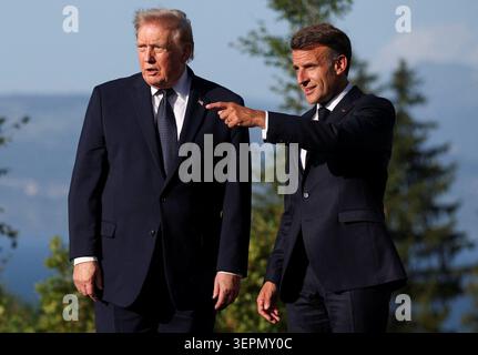 Der französische Präsident Emmanuel Macron (rechts) zeigt neben US-Präsident Donald Trump beim G7-Gipfel in Evian, Frankreich. Bilddatum: Montag, 15. Juni 2026. Stockfoto