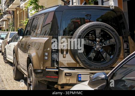 Batumi, Georgia - 09. Juni 2026: Rückansicht eines luxuriösen Land Rover Defender SUV aus Bronze mit Reserverad an der Hintertür, Nahaufnahme. Stockfoto