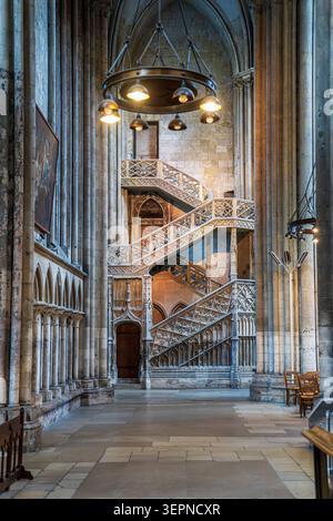 Eindrucksvoller vertikaler Blick auf das Innere der Kathedrale von Rouen. Die Aufnahme zeigt einen großen runden Kronleuchter, der im Vordergrund und im Hintergrund beleuchtet wird Stockfoto