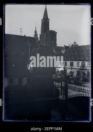 Ein Foto zeigt den Straßburger Dom im Jahr 1859 unter hinterleuchteten Bedingungen und zeigt die Silhouette der Kathedrale Notre-Dame von Straßburg mit ihrem Glockenturm und den umgebenden Strukturen im Elsass. Stockfoto