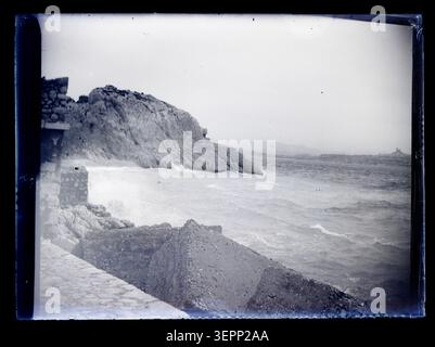 Die Küstenszene im Atlantik zeigt Wellen, die gegen felsige Küsten- und Pier-Strukturen brechen und dynamische Meeresbedingungen und Küstengeologie in der Dokumentation der Meereslandschaft von Eugène Trutat aus dem 19. Jahrhundert erfassen. Stockfoto