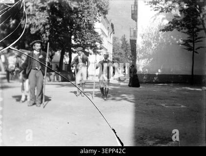 Ein reisender Bärenkünstler unterhält ein Publikum im September 1900 in Luchon und präsentiert eine ausgebildete Tierart in einem öffentlichen Bergresort, wo sich die Zuschauer treffen, um eine Street-Style-Ausstellung zu sehen, die typisch für die Unterhaltung im Süden Frankreichs ist. Stockfoto