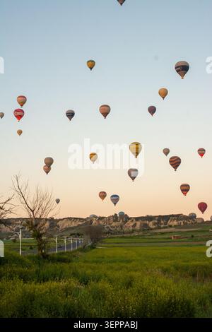 Malerische Aussicht auf farbenfrohe Heißluftballons, die über die einzigartige Landschaft Kappadokiens, Türkei, fliegen. Stockfoto