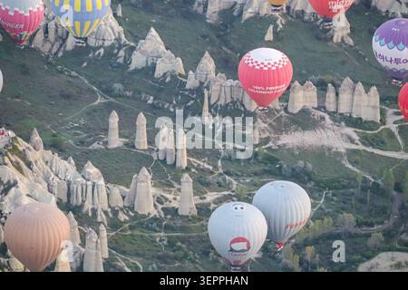 Ein atemberaubender Blick auf farbenfrohe Heißluftballons, die über Kappadokiens einzigartigen Felsformationen schweben. Stockfoto