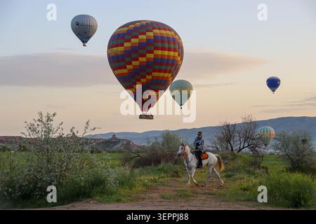 Eine farbenfrohe Szene mit Heißluftballons, die bei Sonnenaufgang über die einzigartige Landschaft Kappadokiens schweben. Stockfoto