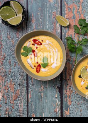 Vertikale Essenskomposition mit cremiger Kürbissuppe und thailändischen Aromen Stockfoto