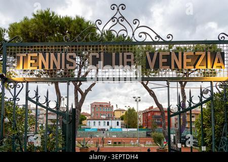 Lido di Venezia, Venedig, Italien - 25. Oktober 2025: Das kunstvoll verzierte, eiserne Eingangstor des Tennisclubs Venezia mit Lehmplätzen im Hintergrund Stockfoto