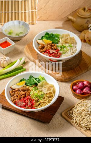 Zwei köstliche asiatische Nudelschüsseln mit Eiernudeln und Reisvermicelli, serviert mit gebratenem Saibling siu Schweinefleisch, gewürztem Huhn, Wonton-Knödeln und Bok Stockfoto