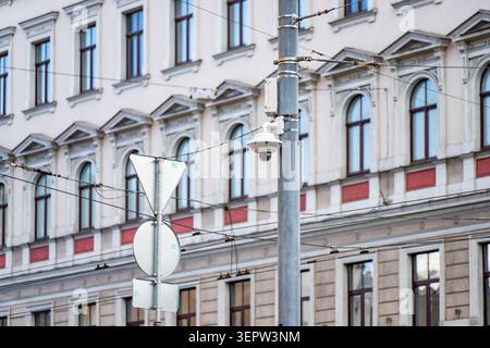 Städtisches Überwachungssystem mit einer Dome-CCTV-Kamera an einer Metallsäule, die den öffentlichen Straßenverkehr und die städtische Umgebung überwacht Stockfoto