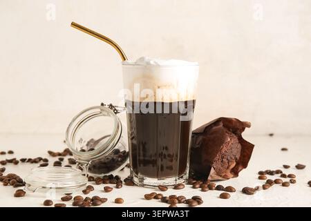 Ein Glas heißer Kaffee mit Schlagsahne und süßem Schokoladenmuffin auf weißem Hintergrund Stockfoto