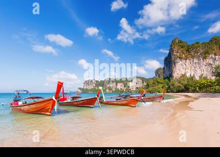 Thailand, Krabi. Longtail-Boot am tropischen Strand mit Kalkfelsen. Stockfoto