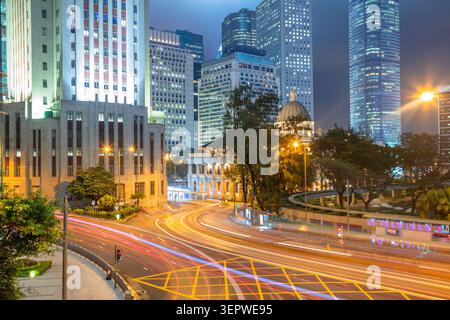 Hong Kong City. Ein Nachtblick auf eine Kreuzung von Hongkong von einem hohen Aussichtspunkt. Wolkenkratzer und Scheinwerferwege Stockfoto