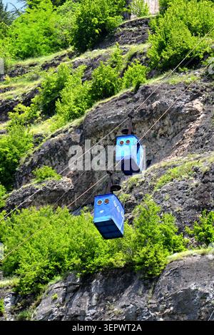 In Chiatura, Georgia, befinden sich alte Seilbahnkabinen über dem Wald und zeigen das berühmte Luftverkehrssystem der Stadt. Stockfoto