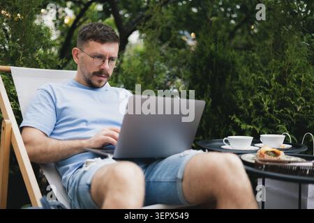 Ein junger Freelancer arbeitet an einem Laptop. Stockfoto