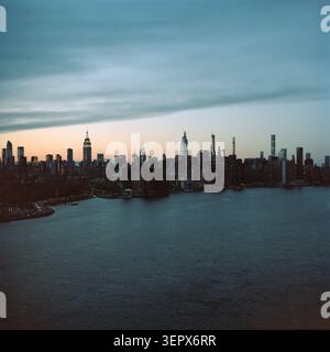 Die Skyline von Midtown Manhattan über den East River in der Abenddämmerung, von der Williamsburg Waterfront in Brooklyn, New York City aus gesehen Stockfoto