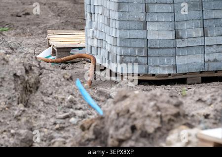 Arbeiter bereiten eine Baustelle mit gestapelten Ziegeln und Erde für Projekte vor. Stockfoto
