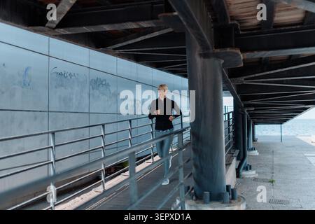 Läuferinnen-Training entlang der Strandpromenade in urbaner Umgebung. Stockfoto