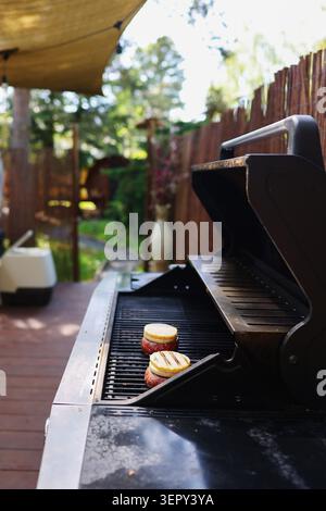 Hausgemachte Burger mit geschmolzenem Käse, die draußen gegrillt werden, köstliches, komfortables Essen, das auf einem Grill zubereitet wird Stockfoto