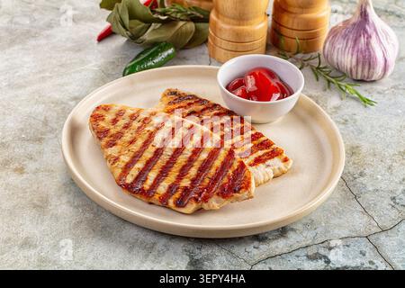 Zwei gegrillte truthahnsteaks mit Saibling-Spuren, serviert mit Ketchup, Knoblauch und Kräutern auf einem beigen Teller. Gesundes Mahlzeitkonzept. Lebensmittelfotografie Stockfoto