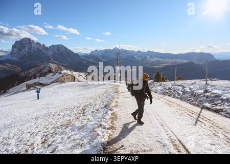 Wanderer auf einem schneebedeckten Berg Seceda Trail in den Dolomiten. Herbstliche alpine Landschaft mit frischem Schneefall und Panoramablick auf die Berge Stockfoto