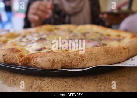 Frisch gebackene Pizza auf einem Tisch in einem lokalen Restaurant Stockfoto