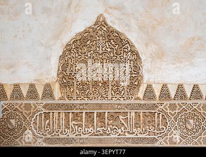 Detaillierte Ansicht von feinen maurischen Stuck-Arabesken-Mustern und arabischen kalligraphischen Inschriften auf einer Gipswand an der Alhambra, Spanien Stockfoto