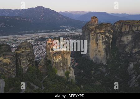 Aus der Vogelperspektive des Heiligen Klosters von Varlaam auf einer Felssäule bei Meteora mit der Stadt Kalabaka und den Bergen im Hintergrund Trikala, Griechenland. Stockfoto