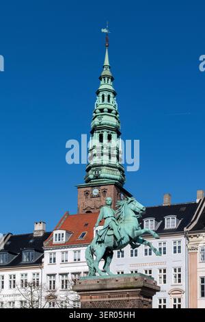 Kopenhagen, Dänemark-11. April 2026; Niedrigwinkelansicht der Statue des Bischofs Absalon auf Hojbro-Platten und des Turms der ehemaligen Nikolaikirche im Hintergrund Stockfoto
