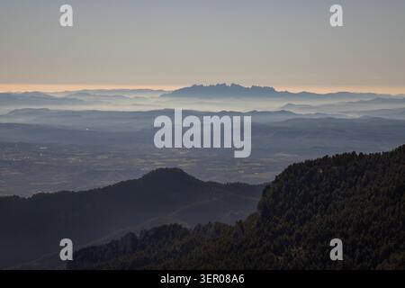 Montserrat Gebirgszug, der durch atmosphärische Nebelschichten auftaucht Stockfoto