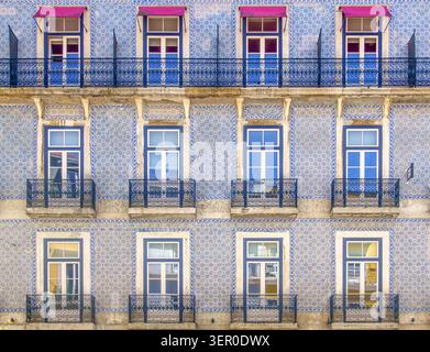 Historische portugiesische Azulejo-Fassade in Blau mit schmiedeeisernen Balkonen und symmetrischen Fenstern Stockfoto