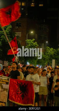 Tirana, Albanien – 17. Juni 2026: Demonstranten halten albanische Nationalflaggen, während sie an einer nächtlichen Demonstration im Zentrum von Tirana teilnehmen. Stockfoto