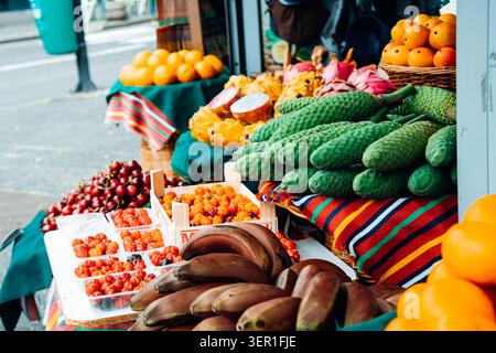 Eine lebhafte Nahaufnahme einer exotischen Obstpräsentation im Freien auf einem traditionellen Markt auf Madeira, Portugal. Der Stand bietet einzigartige regionale Spezialität Stockfoto