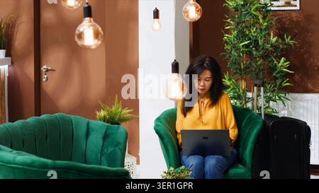 Asiatische Touristen erstellen einen Reiseplan, um Sehenswürdigkeiten zu besuchen, indem sie das Internet nutzen, während sie auf den Check-in-Prozess wartet. Stockfoto