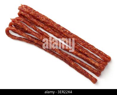 Dünne geräucherte Wurst auf weißem Hintergrund. Kabanos Wurst. Ansicht von oben Stockfoto