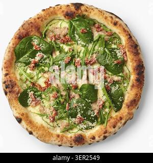 Blick von oben auf eine vegetarische Pizza mit Zucchini, Spinat, sonnengetrockneten Tomaten und Parmesankäse mit appetitlichen Zutaten Stockfoto