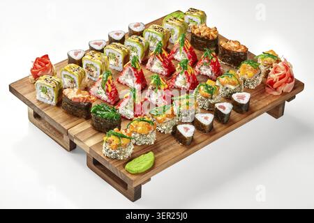 Buntes Sushi-Sortiment mit Maki, Uramaki und Nigiri, serviert auf einem Holzbrett, garniert mit Wasabi und Ingwer Stockfoto