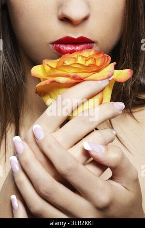Nahaufnahme des unteren Teils des Mädchengesichts mit gelber Rose Stockfoto