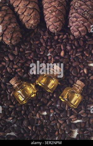 Das Zedernöl in Glasflaschen auf die Zedernnüsse Stockfoto