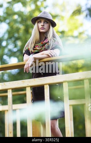 Junge hübsche Frau auf einer kleinen Holzbrücke Stockfoto